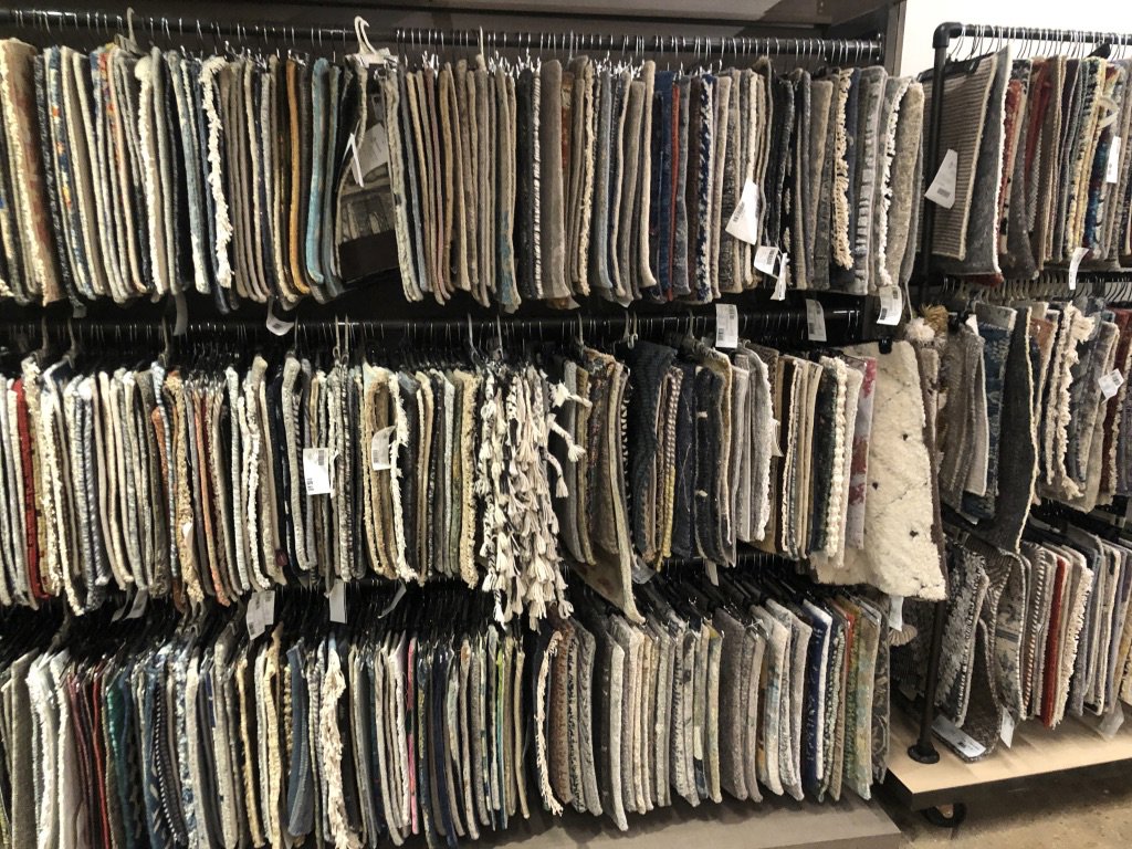 A wide selection of carpet and rug samples hanging on display at Artifacts Fine Rugs and Flooring in South Salt Lake, UT.