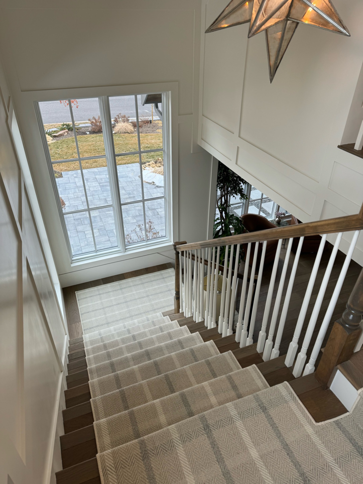 A beautifully installed carpet runner on a residential staircase by Carpet One Floor & Home Denver in Denver, CO.