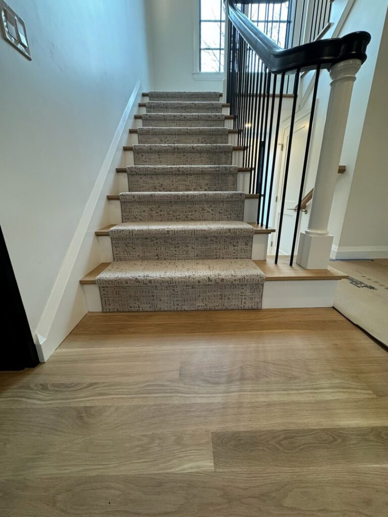 A newly installed carpet runner on a staircase by Harry's Carpet One in Quincy, MA.