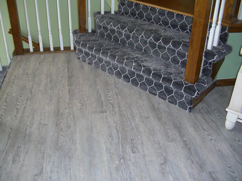 A newly installed carpet runner on stairs next to hardwood flooring by All Dimension Floor Care in Lenexa, KS.