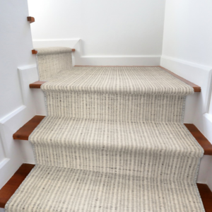 A newly installed striped carpet runner on wooden stairs by Carpet World Fargo, ND