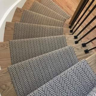 A stylish carpet runner with a herringbone pattern installed on wooden stairs by Sy's Discount Carpets in Los Angeles, CA