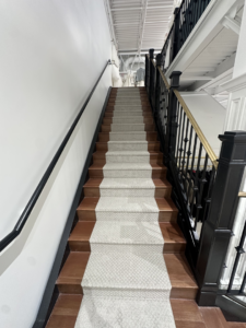 Carpet runner installation on a wooden staircase by Best Flooring in Indianapolis, IN.
