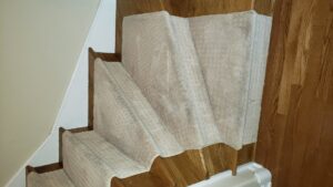 Newly installed carpet runners on wooden stairs by Anderson Certified, INC. in Chicago, IL.