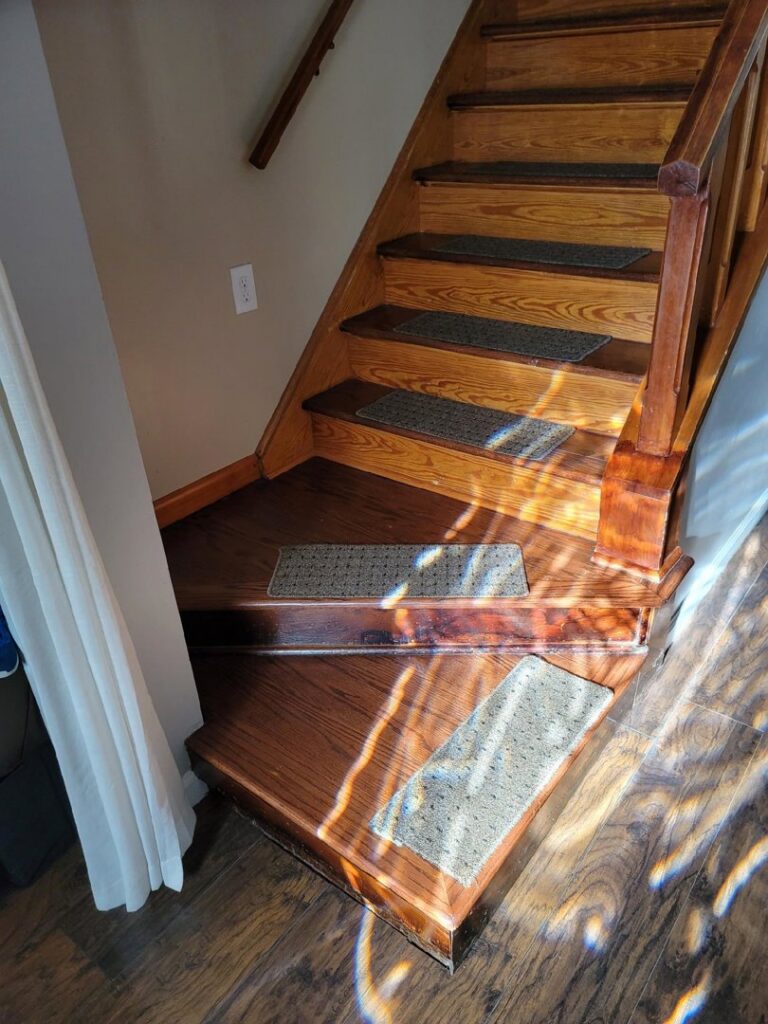 Carpet runners installed on a wooden staircase by Modern Flooring & Renovations WNY in Tonawanda, NY.