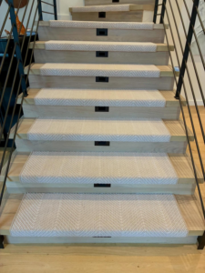 Professional carpet runners installed on wooden stairs by Trademark Flooring in West Jordan, UT.