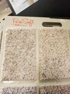 A close-up of PureSoft carpet samples on a display board at Trendsetters Flooring in Benbrook, TX