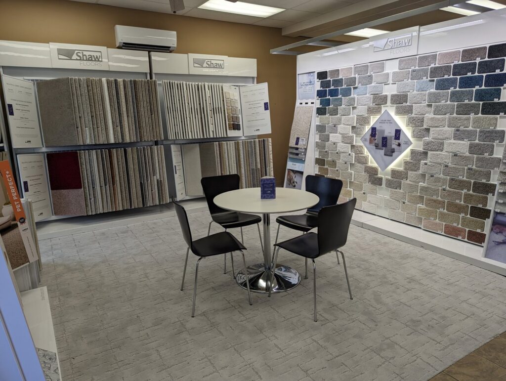A bright showroom area featuring a large wall display of various carpet samples at Petersen's Carpet & Flooring in Frederick, MD