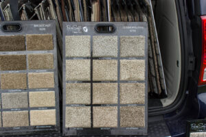 Carpet samples displayed on two boards in a vehicle, showing options from Home Based Carpet & Flooring in Cincinnati, OH.