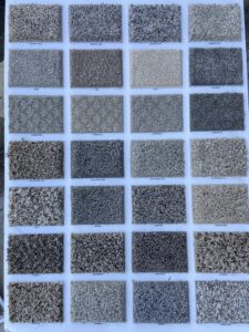 A display board showcasing various carpet samples and textures available at Castro's Carpet in Houston, TX.