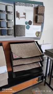 A display rack showcasing various carpet samples and textures at Dunedin Floors & Granite in Tampa, FL.