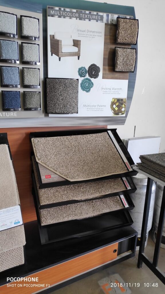 A display rack showcasing various carpet samples and textures at Dunedin Floors & Granite in Tampa, FL.