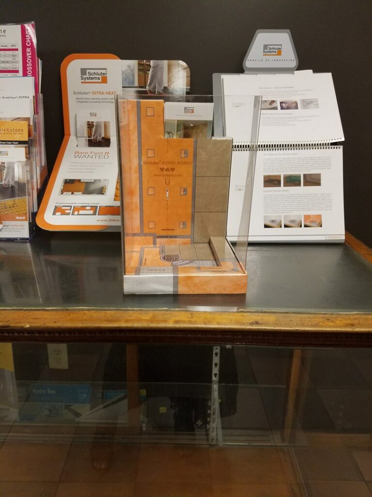 Close-up of various carpet samples displayed on the floor at Palmetto Tile Columbia in Columbia, SC.