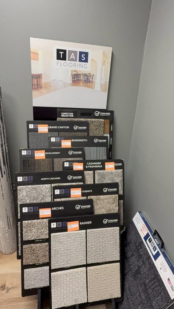 A showroom display featuring various carpet samples and a carpet pad selector at Symbols Flooring in Soldotna, AK