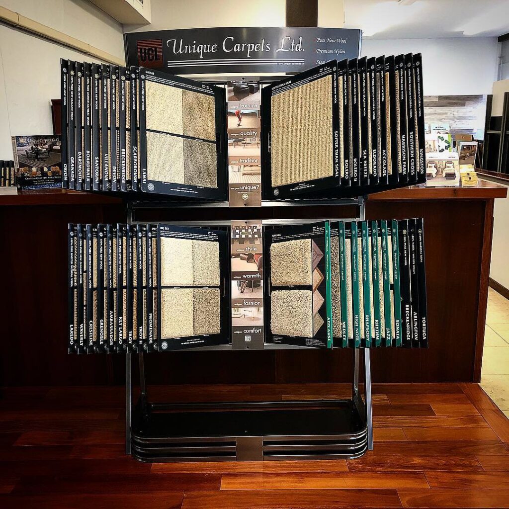 A display stand showcasing various carpet samples from Unique Carpets Ltd. at Kahala Floors in Honolulu, HI.