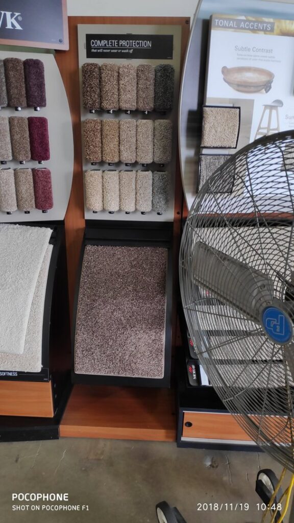A showroom display featuring various carpet samples and textures at Dunedin Floors & Granite in Tampa, FL.