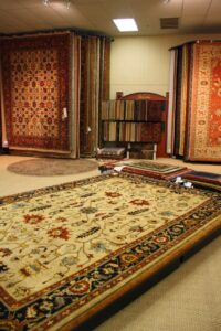 A vibrant carpet showroom displaying large area rugs and hanging carpets at Jimmie Lyles Flooring Gallery in Flowood, MS