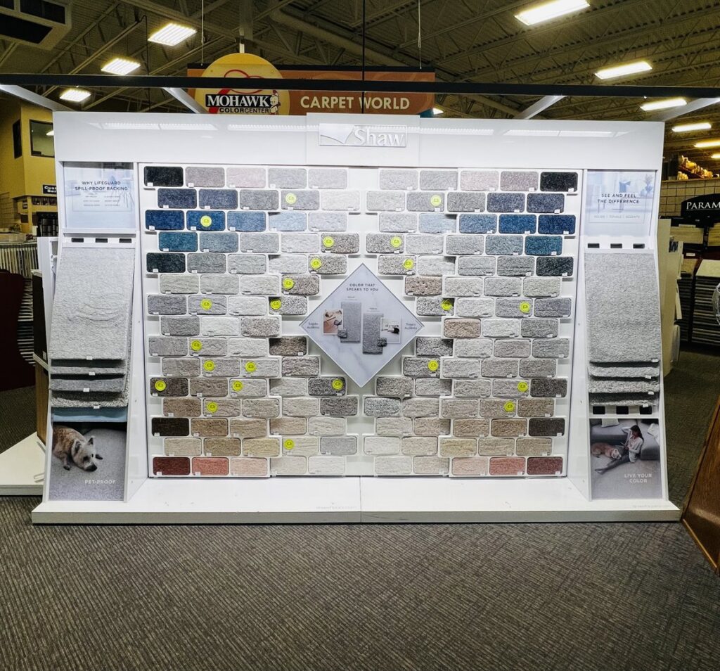 Interior view of the Carpet World Fargo, ND showroom with various carpet samples and a decorative globe