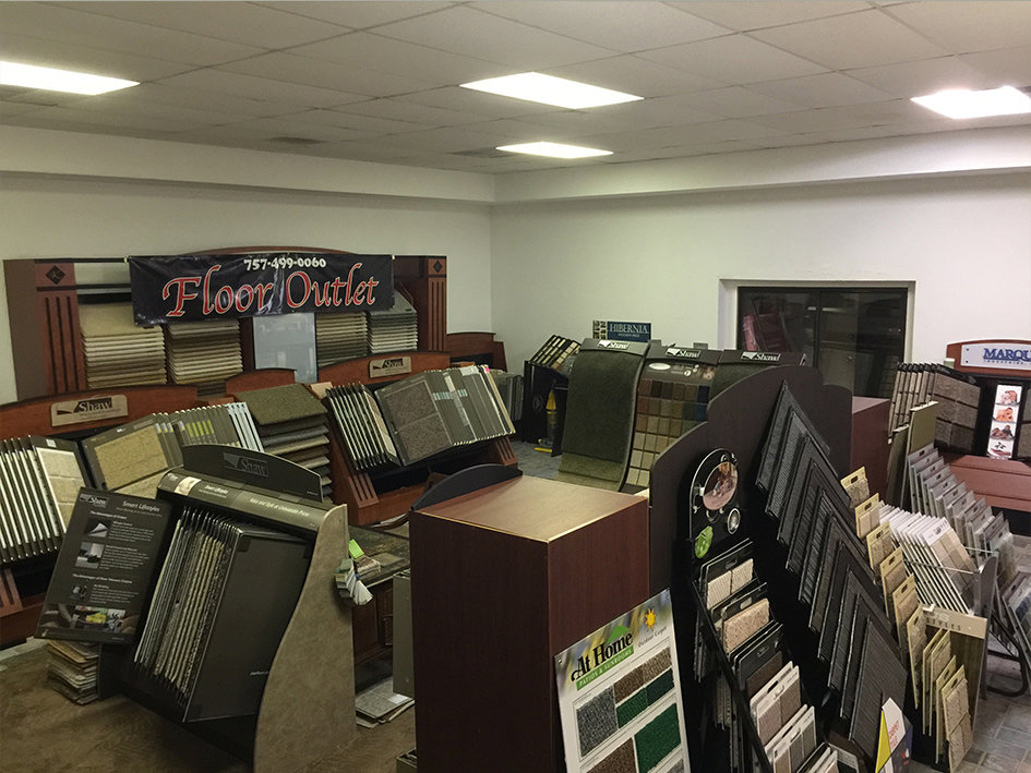 An interior view of the carpet showroom displaying various carpet rolls and samples at 1 in ALL GC in Virginia Beach, VA.