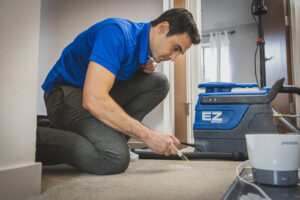 A technician performing spot cleaning on a carpet with a portable machine for North Seattle Carpet Cleaning in Seattle, WA