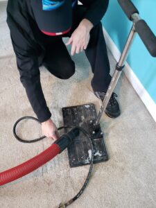 Carpet cleaning technician performing spot removal with a specialized tool for Professional Carpet Systems of Raleigh, NC
