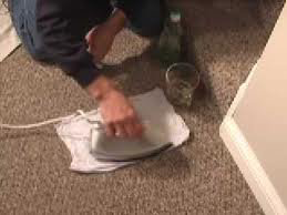 A professional using an iron and cloth for carpet stain removal at Carpet Care Express in Garland, TX