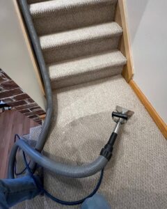 Carpet cleaning in progress on stairs using professional equipment by Trent's Carpet Cleaning & Restoration in Fishers, IN.