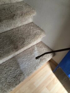 A carpet cleaning wand spraying water to clean a carpeted staircase by All Kleen Carpet Cleaning in Mountlake Terrace, WA.