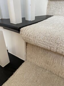 Detailed view of light-colored carpet installation on stairs by Floor Gallery in Pearland, TX