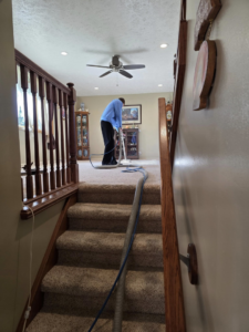 A professional performing carpet steam cleaning in a residential home for Extreme Steam Cleaning in Milwaukee, WI.