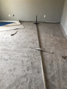 Carpet stretching and installation in progress with a power stretcher tool, performed by S&H Floor Covering in Cross Junction, VA.