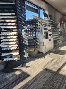 A showroom displaying carpet tiles on the floor alongside various tile and flooring samples at Jerry's Carpet Sales and Service in York, PA.