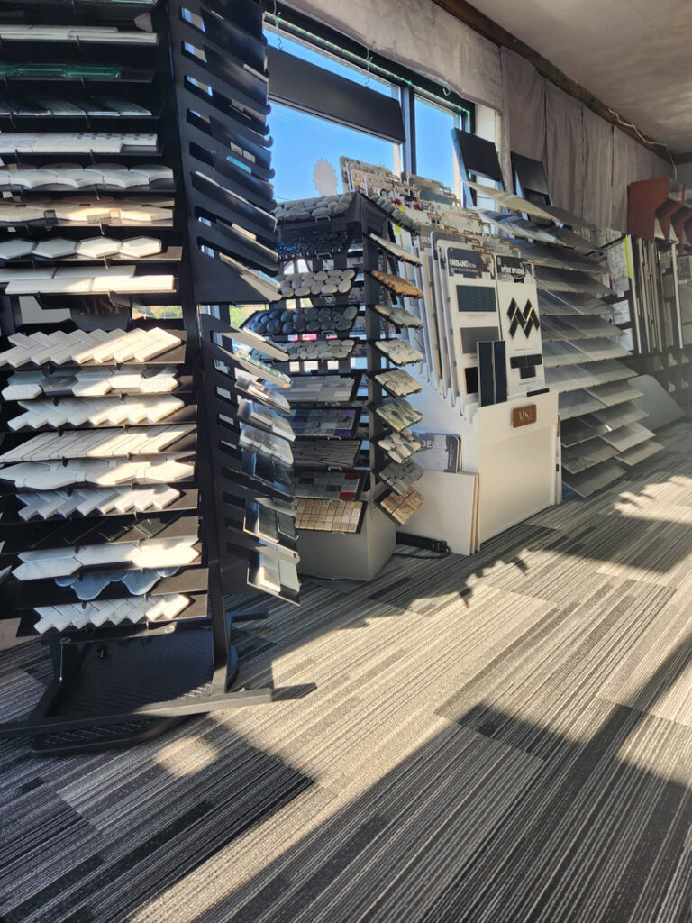 A showroom displaying carpet tiles on the floor alongside various tile and flooring samples at Jerry's Carpet Sales and Service in York, PA.