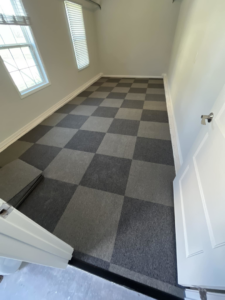 A room featuring newly installed checkered carpet tiles by Alpha Hardwood Floors in Overland Park, KS.