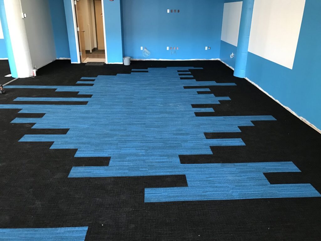 Carpet tile installation in progress in a commercial space by CAP Flooring in Buffalo, NY
