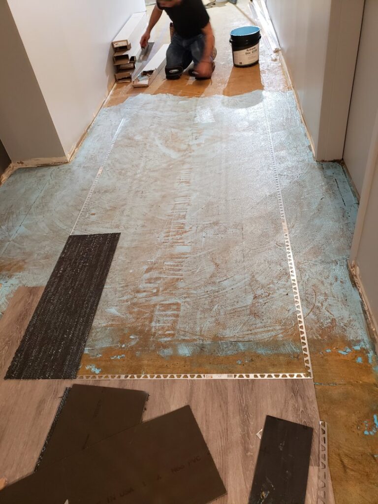 Worker installing carpet tiles over a prepared subfloor by Chicago Floor Systems in Chicago, IL