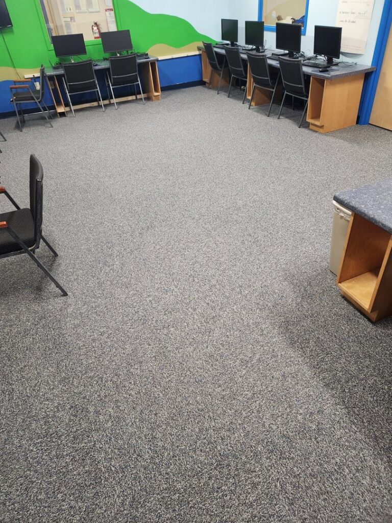 Carpet tiles being installed in a commercial space, showing work in progress by Carpet Center in Nashua, NH.