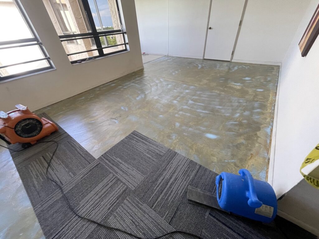 Carpet tile installation in progress with air movers in a commercial space by Global Flooring Enterprise in Miami, FL.