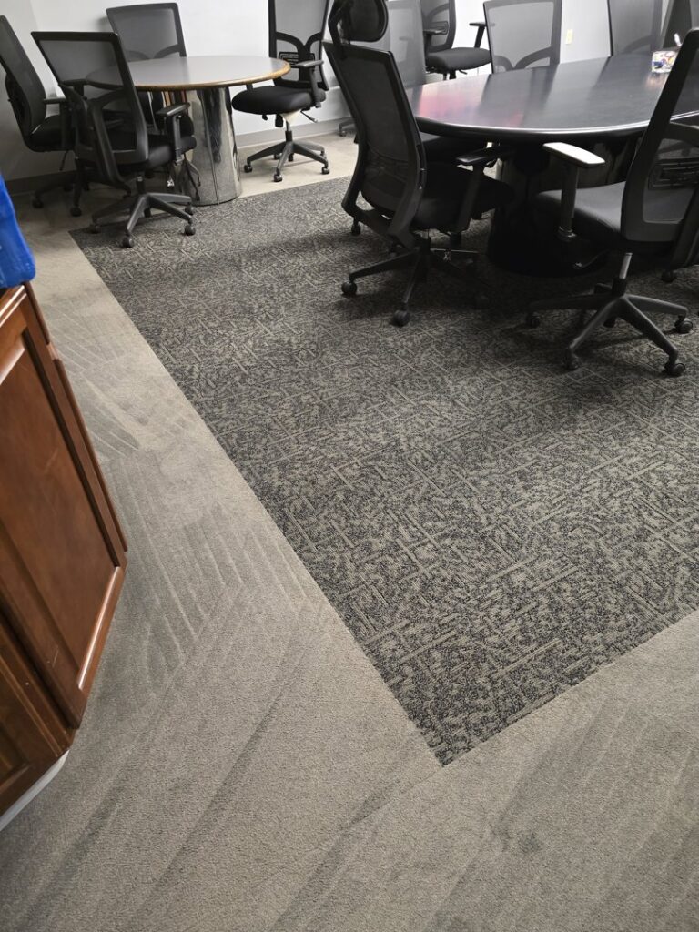 Carpet tiles in an office showing a cleaned section by Legendary Carpet Care+ in Toledo, OH.