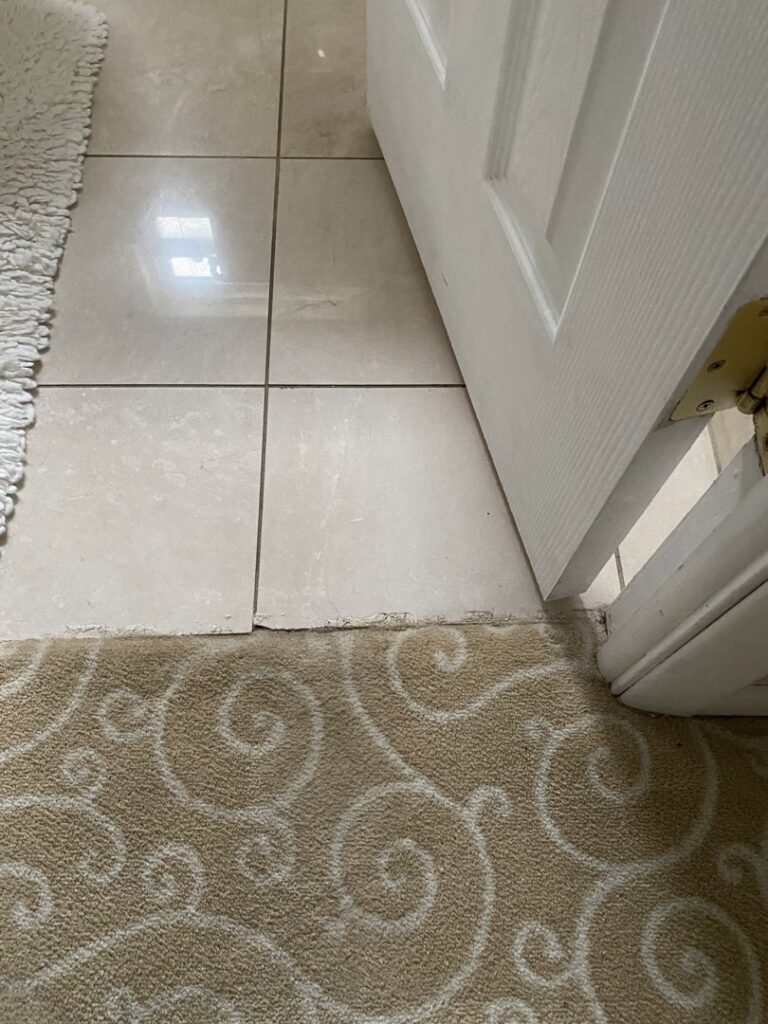 Close-up of a professional carpet to tile transition installation by Carpet Warehouse Lorain LLC in Lorain, OH.