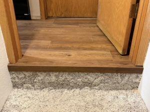 A clean transition from new vinyl plank flooring to carpet on a step by B.A.M Vinyl Flooring LLC in St Charles, MN