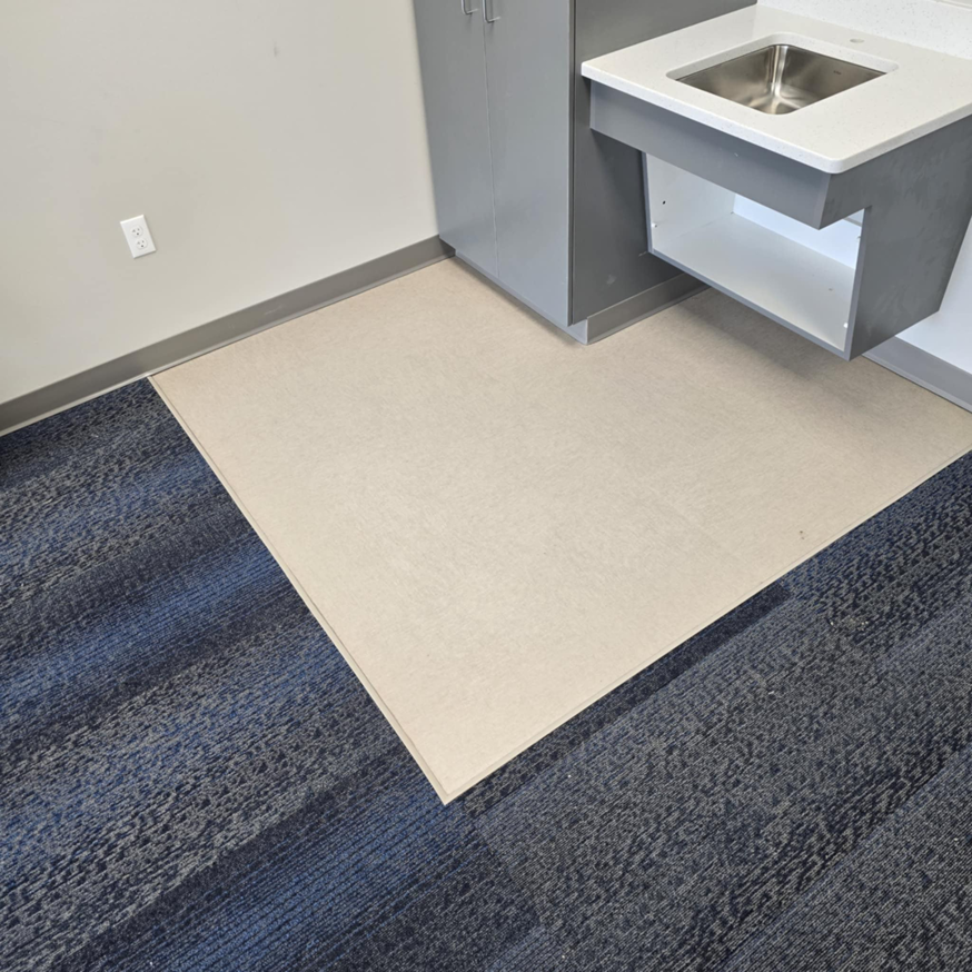 Carpet transition installation from blue patterned to light solid carpet by LaValle Flooring Inc - Jamestown, ND