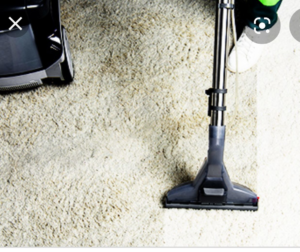 A vacuum cleaner creating a clean strip on a light-colored carpet, demonstrating a carpet cleaning service from Carpet Cleaning - American Way in Danbury, CT.