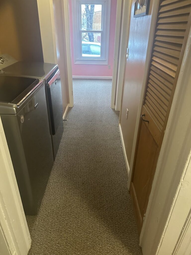 Carpeted hallway leading to a laundry area, installed by WCW Carpet Warehouse in Bennington, VT