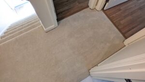A newly carpeted landing and staircase, showcasing professional installation by National Carpet and Flooring in Tyngsboro, MA.