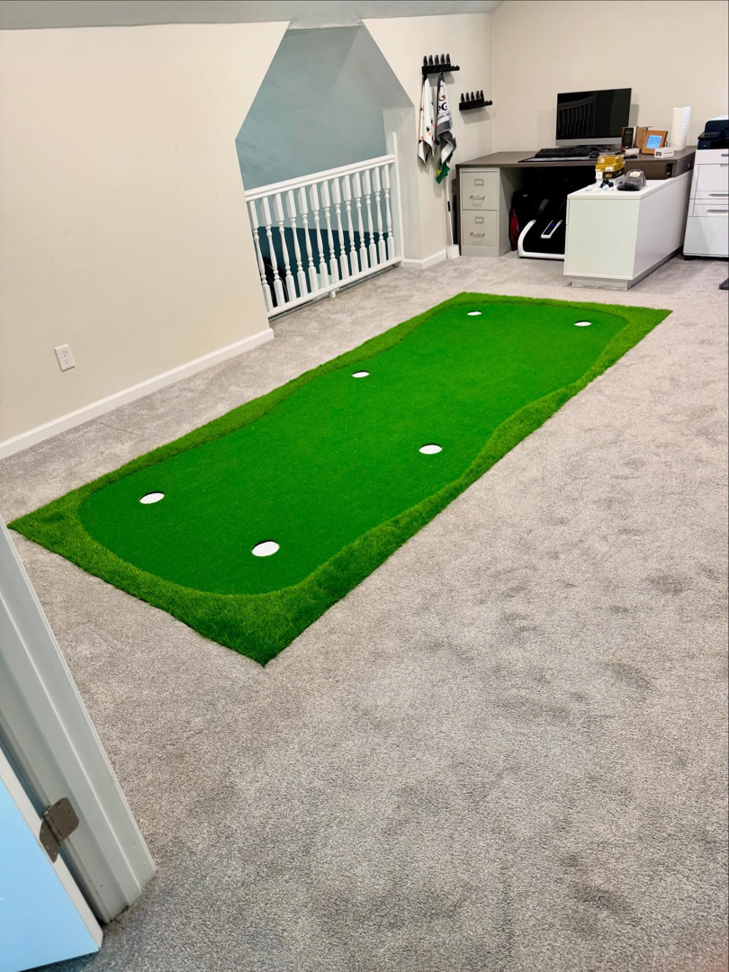 A newly carpeted room featuring a gray carpet and an indoor putting green installed by Floors To Go in Virginia Beach, VA.