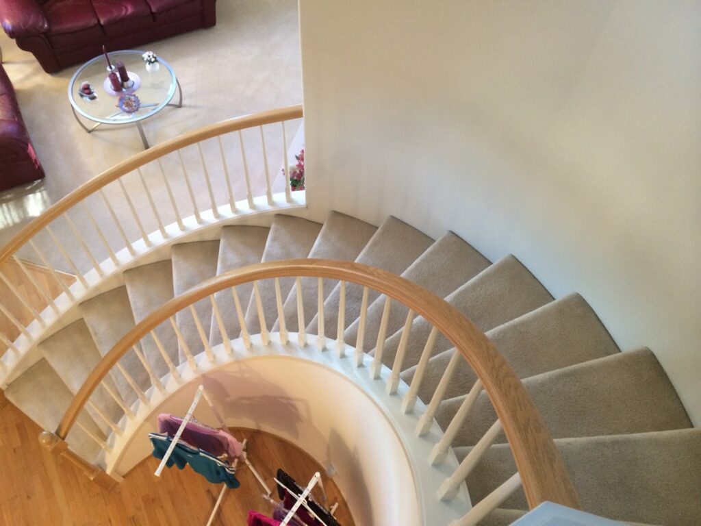 A beautifully carpeted spiral staircase installed by Dream Hardwood Floors, LLC in Bellevue, WA.