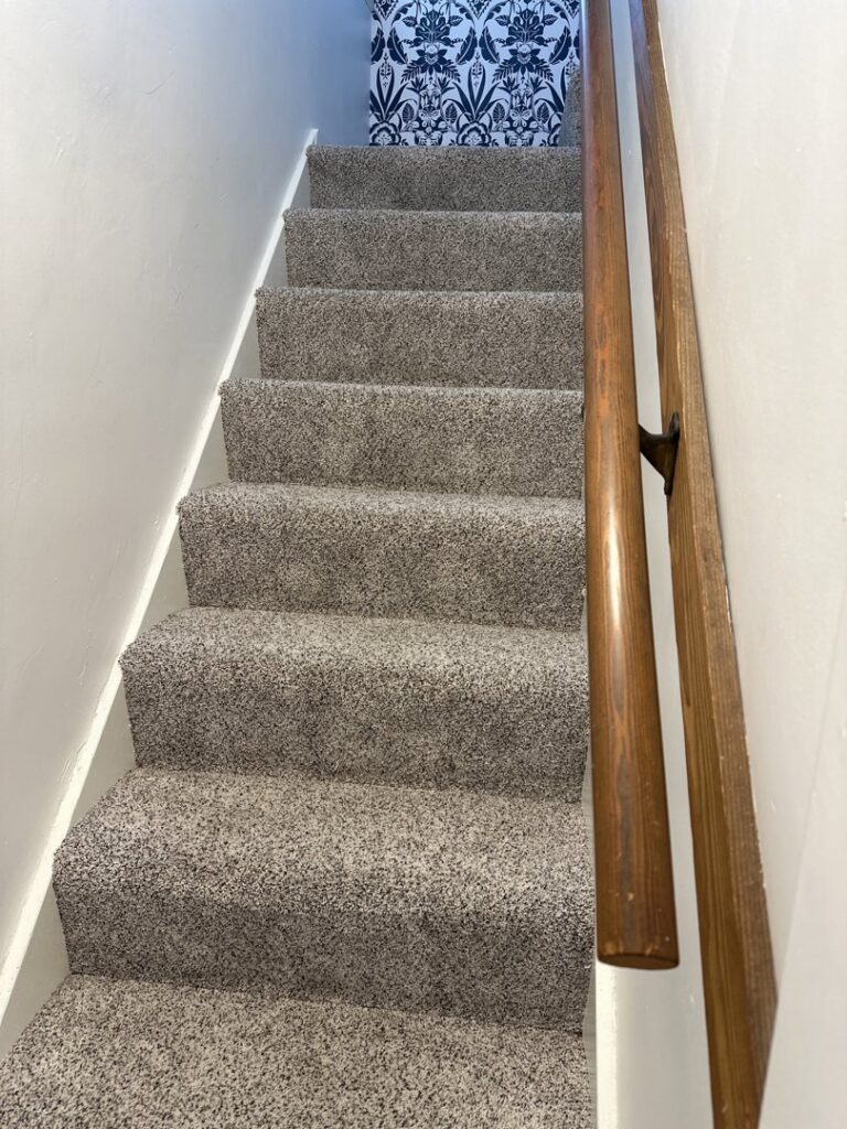 A clean, carpeted staircase, representing cleaning services by A-1 Kwik Dry Carpet Cleaning in Louisville, KY.