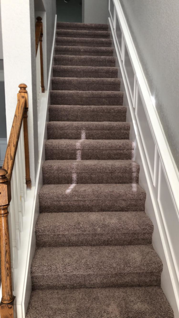 A newly carpeted staircase with brown carpet installed by First Quality Carpets Inc. in Orlando, FL