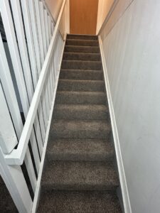 A newly carpeted staircase with durable gray carpet installed by Wilkins Floorcovering in Livonia, MI